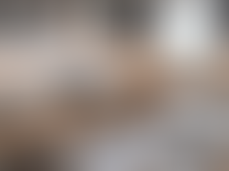 Kitchen renovation in progress with unfinished cabinets, design plans, tools, and material samples on a countertop during a home remodel budgeting and planning phase.