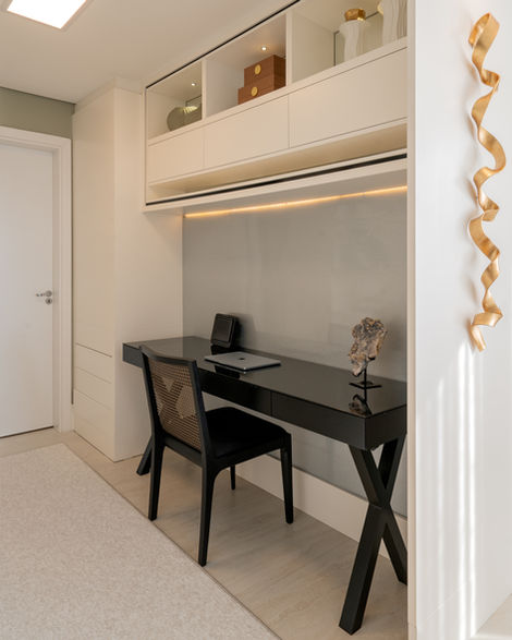 Auge apartment home office with a dark desk, comfortable chair and built-in shelving.