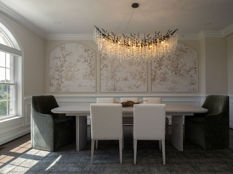 Olive Grove dining room with botanical wallcovering, upholstered chairs and a delicate chandelier.