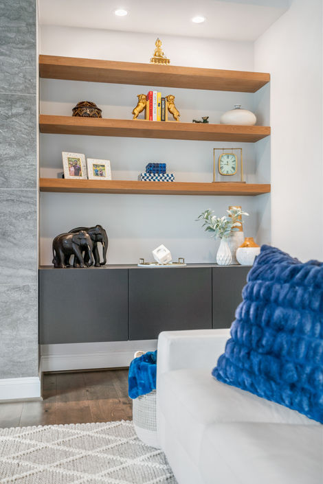 Living room detail with open wood shelving and a blue accent pillow.