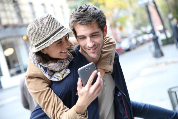 Couple looking at the 8 must have luxury travel apps on phone
