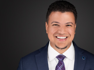 Executive headshot of a man in a suit and tie with clean, professional lighting and a friendly expression