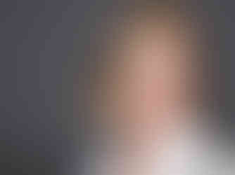 Studio portrait of a woman with soft styling and neutral tones with flattering lighting and confident expression