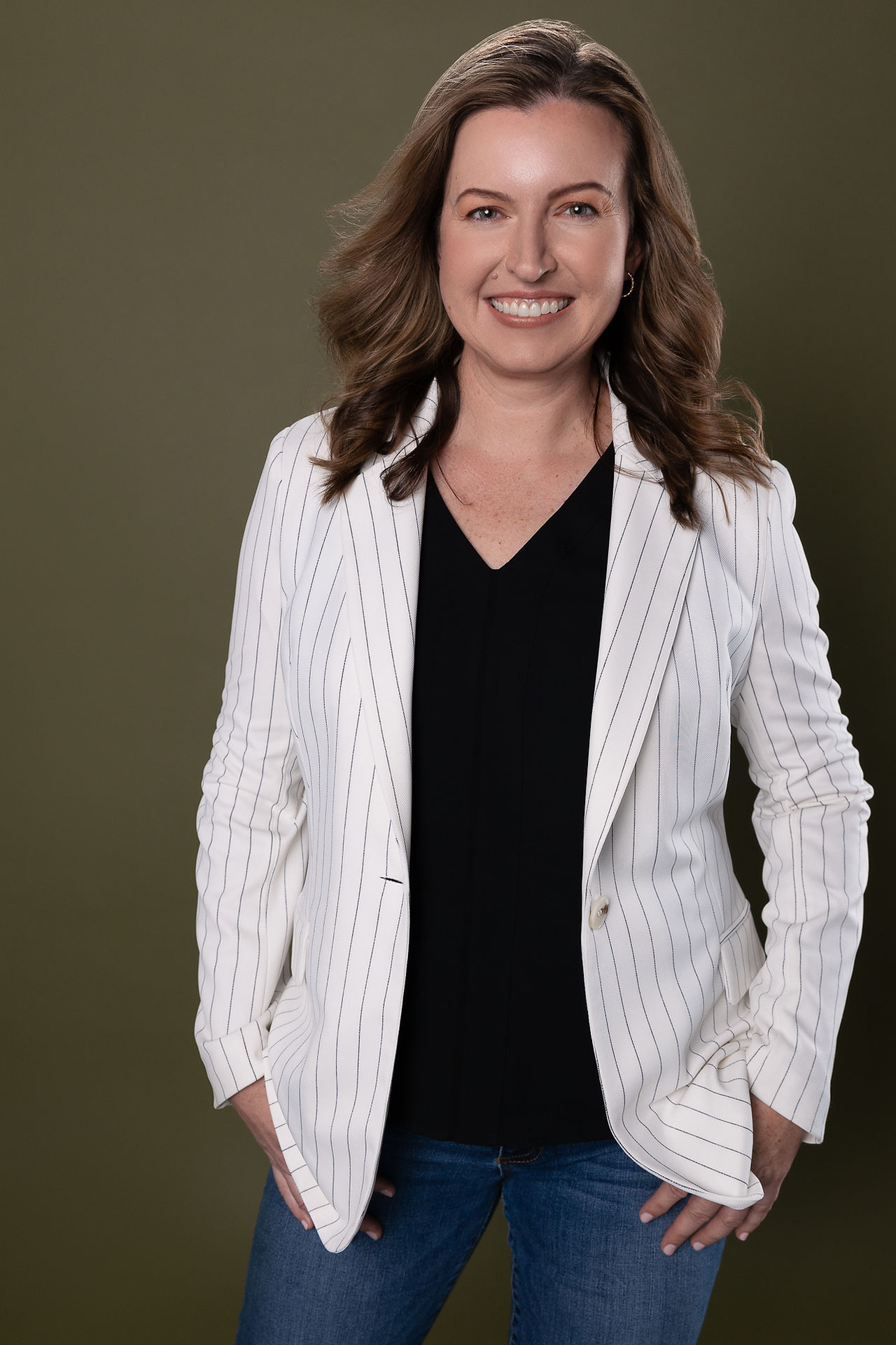 Modern headshot of a woman in a textured suit jacket with soft lighting and approachable expression