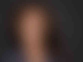 Studio headshot of a Black woman CEO in tailored attire with natural expression and well balanced lighting