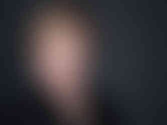 Professional headshot of a woman with short hair wearing a black top with polished styling and soft studio lighting