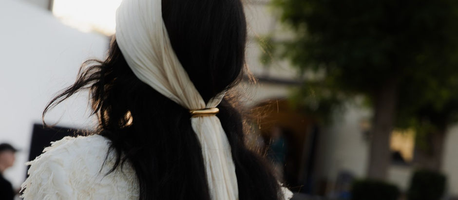 Women at a fashion show wearing a white scarf on her head