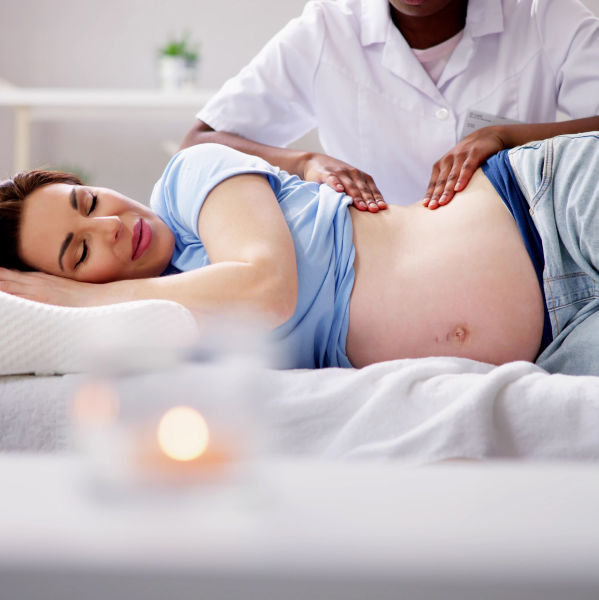 A pregnant woman resting, highlighting the importance of prenatal massage sessions.