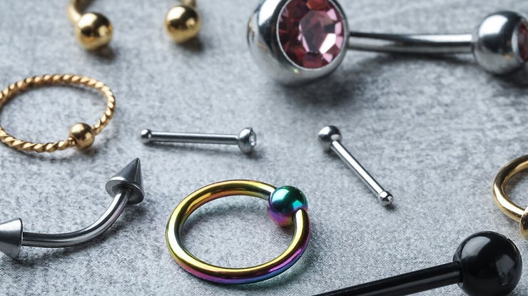 Une variété de bijoux de piercing exposés sur une table, présentant différents styles et modèles.