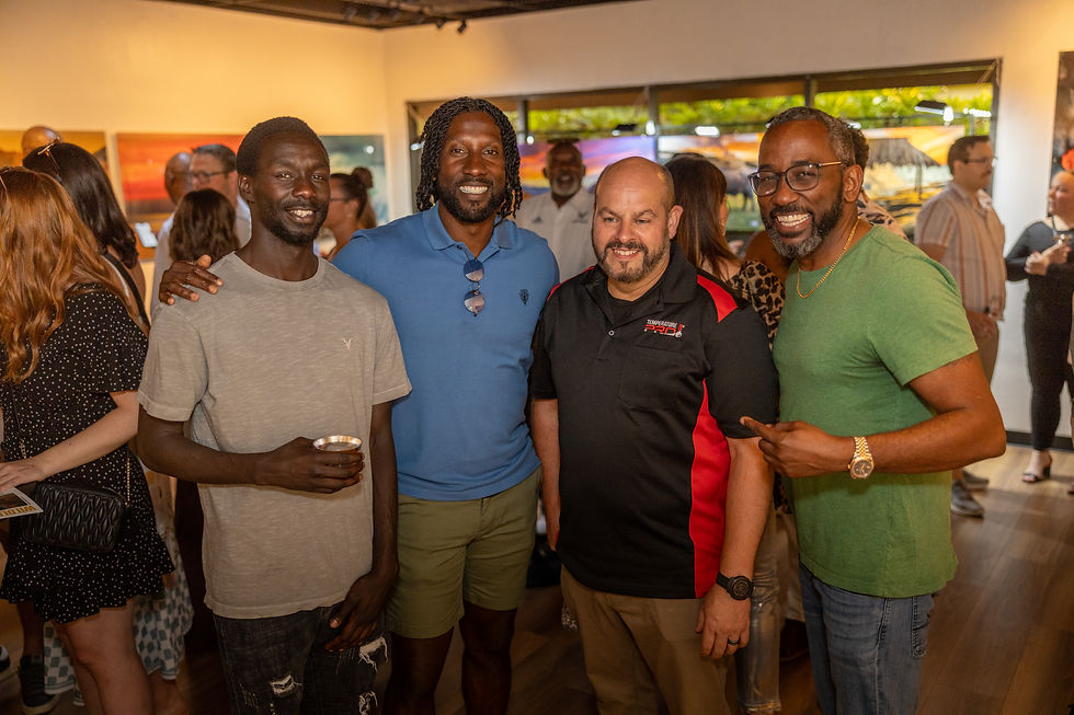 Guests smiling and connecting inside The Frederick Collection gallery, reflecting Norris Frederick’s legacy of impact, community, and art beyond athletics.