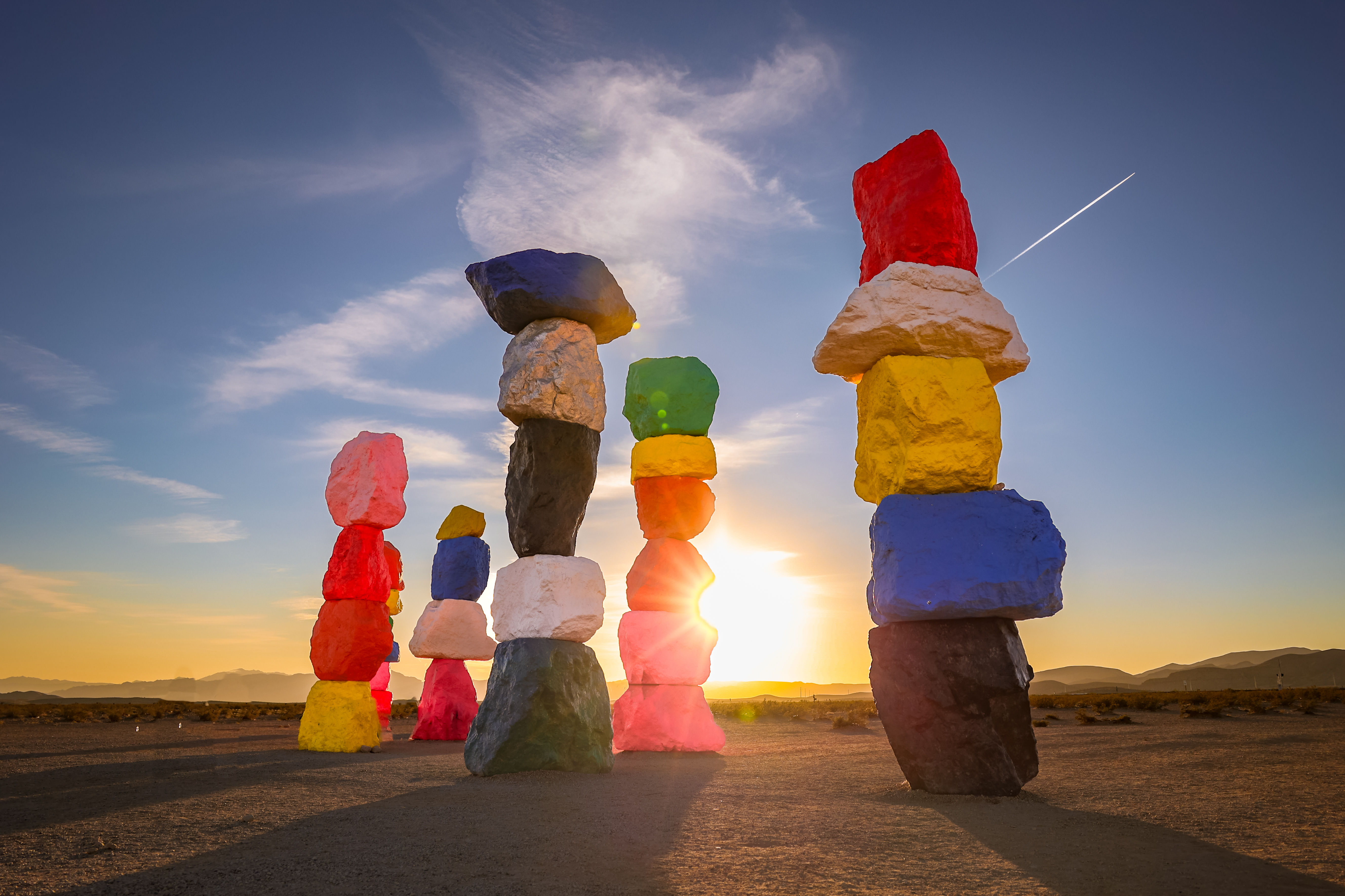 Colorful stacked boulders from the Seven Magic Mountains art installation in the Nevada desert, captured at sunset with a glo