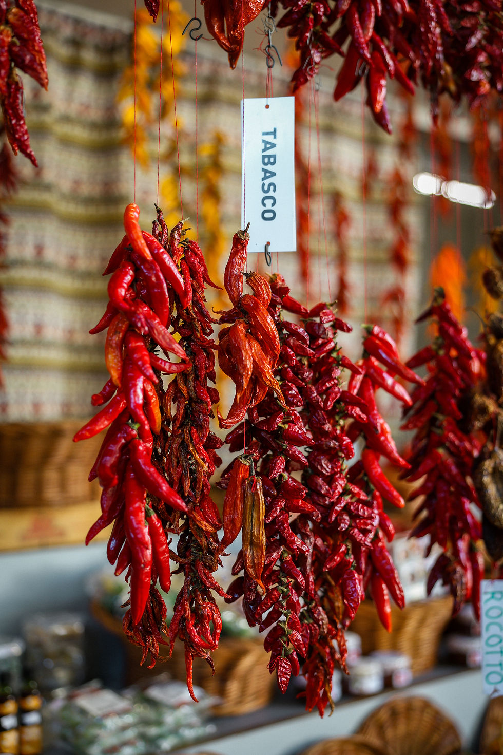 Multi-colored hanging peppers displayed in the farmers market in Funchal, Portugal.