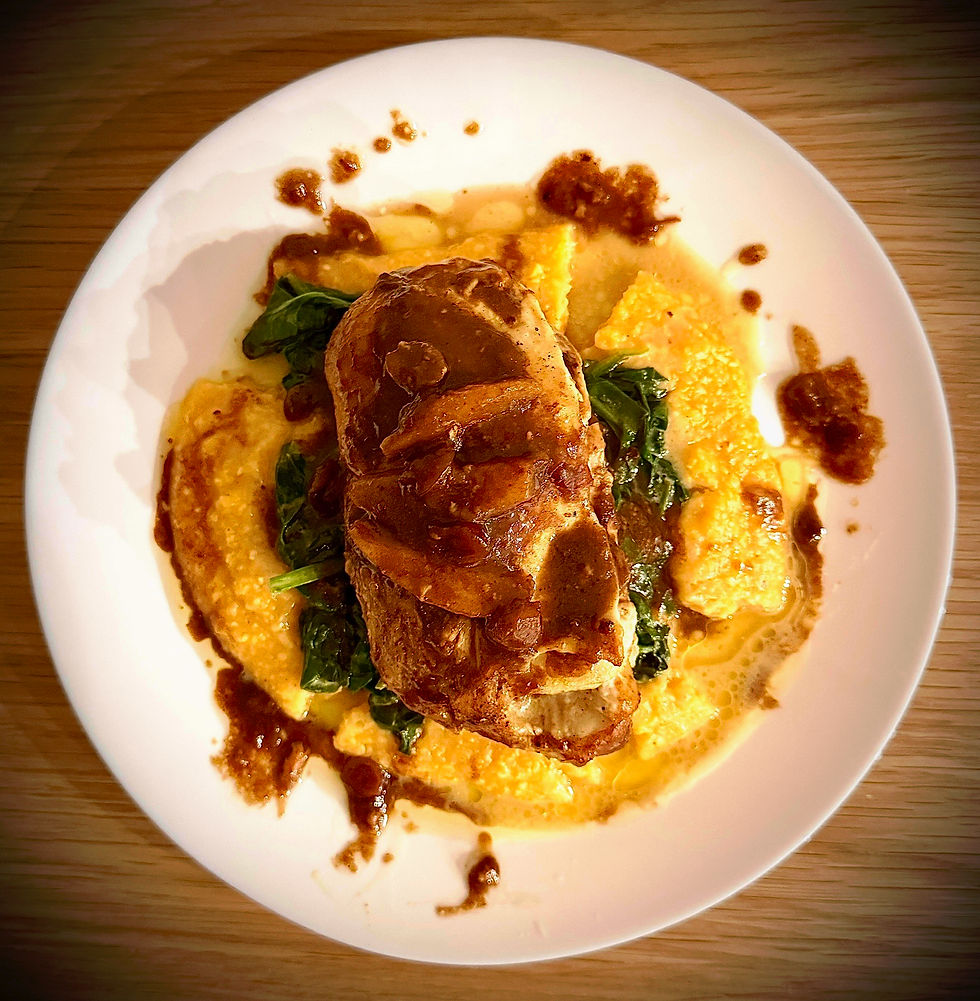 Braised Chicken Breast Stuffed with Apples, Cranberry and Brie                                                                      Braised in a house made Apple Butter and Brown Butter Pan Gravy                                                                  served here with hearty winter polenta and preserved lemon wilted spinach