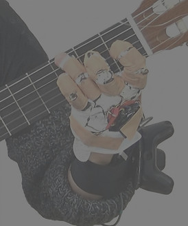 Hand playing guitar while wearing an IMU motion capture glove for research