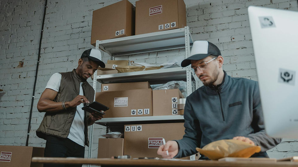 Two warehouse employees organizing and packing parcels for delivery in a modern indoor setting.