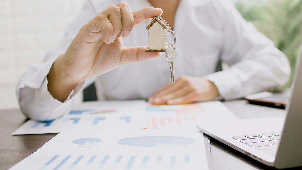 Real estate professional presenting a house model with keys, symbolizing property investment and ownership.
