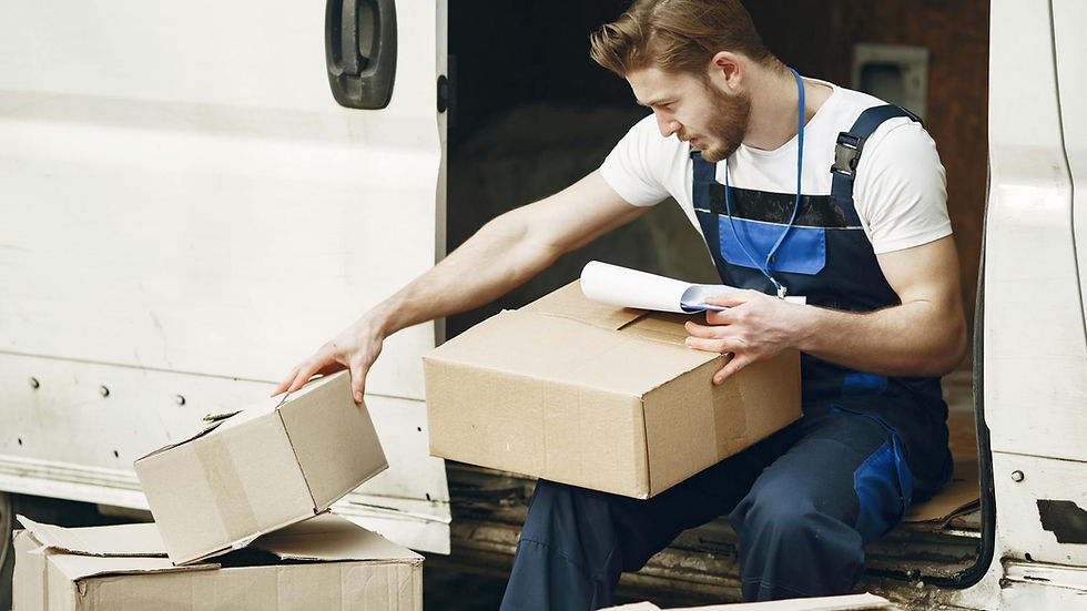 Man in uniform sorts packages by a white van, emphasizing efficient delivery service.