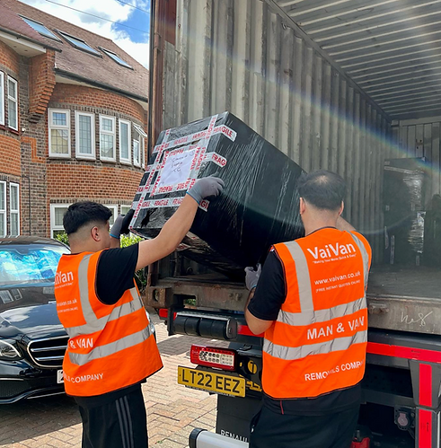 2 VaiVan moving porters loading a container lorry with packed items from a 4 bedroom house