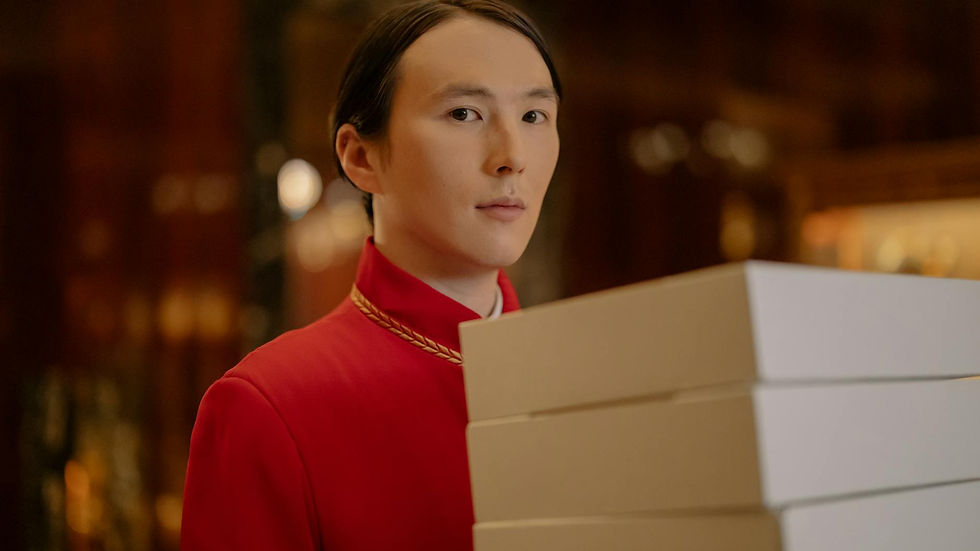 Bellboy in red uniform carrying white packages inside a hotel, highlighting hospitality and service.