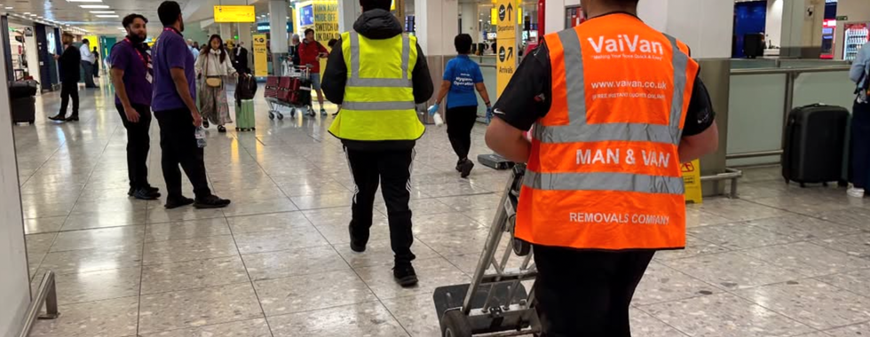 An Airport To Home courier getting ready to meet a customer for collection of bags handover for a transfer at Heathrow Airport arrivals hall meet and greet