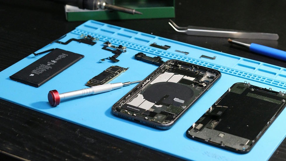 Close-up of disassembled smartphone parts on a blue repair mat with tools.