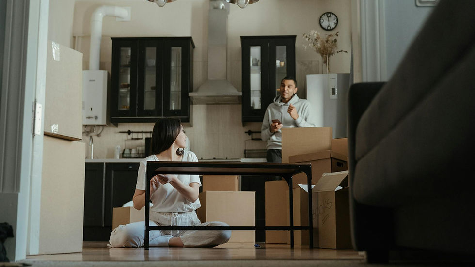 A couple is seen unpacking boxes in their new apartment, setting up their kitchen area.