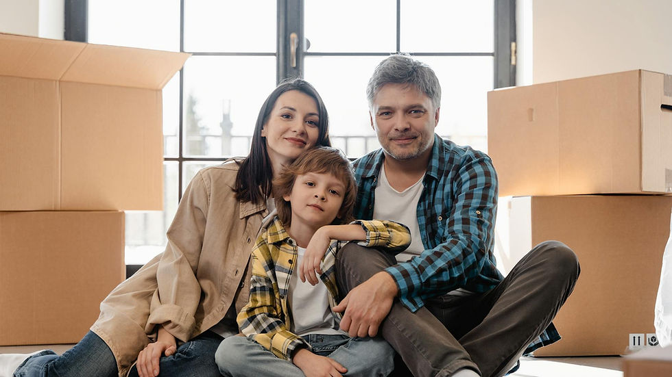 Happy family sitting together in their new home surrounded by moving boxes.