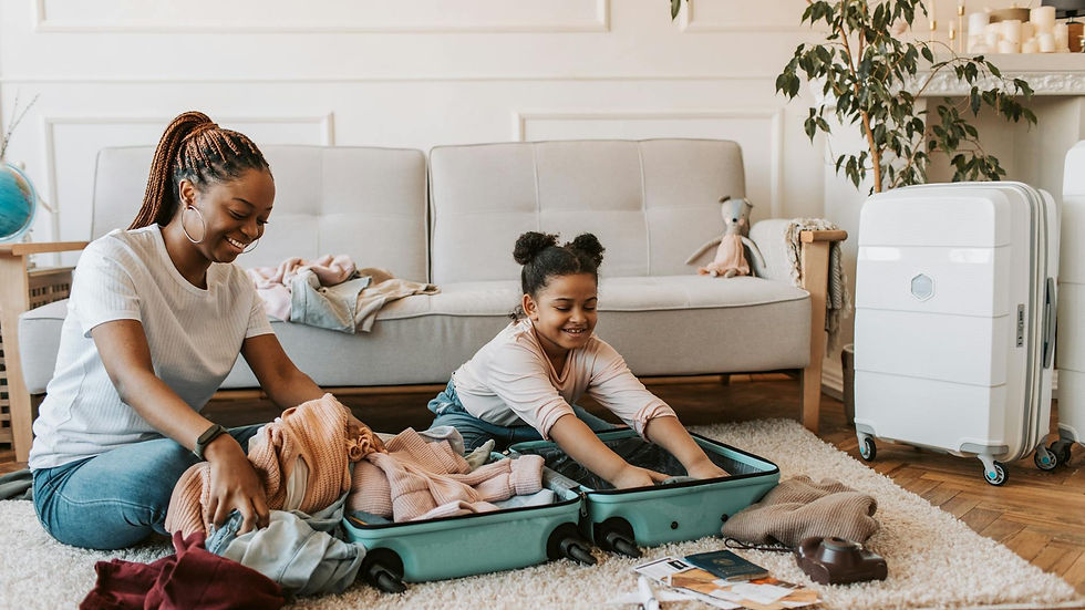 A joyful moment of a mother and daughter packing luggage together in their living room.