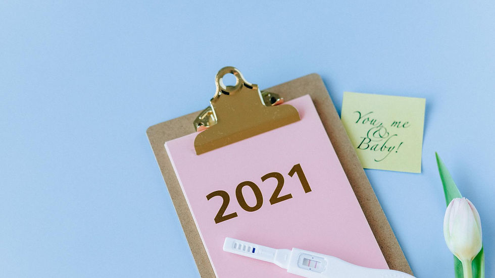 A positive pregnancy test on a clipboard marked 2021, with a note saying 'You, me & Baby!' and a tulip, symbolizing new life.