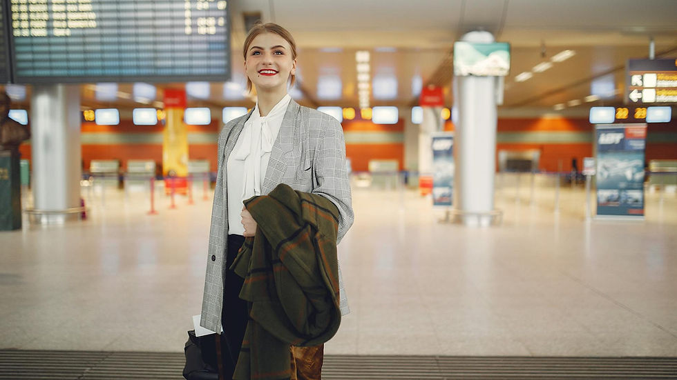 Elegantly dressed businesswoman at a modern airport terminal, ready to travel.