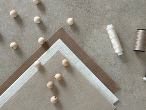 Drie kleuren garen, diverse vilten lapjes en houten kralen