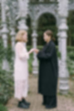 two brides holding hands facing each other