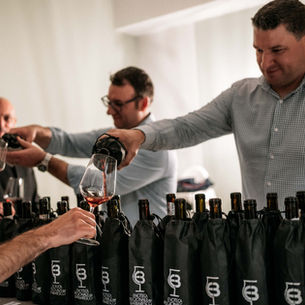 Men pouring wine into glasses