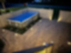 Aerial view of paver patio design surrounding an above-ground pool with accent lighting in Hagerstown, MD, by The Groundskeeper Inc.