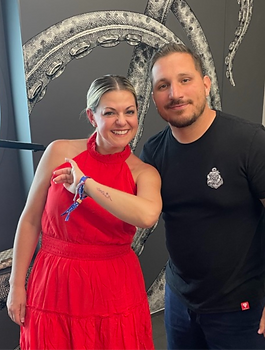 Tatoo artist and canvas showing new tatoo aboard Virgin Voyages
