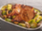 Grilled pork chops with Brussels sprouts, mushrooms, and onions on a white plate. Black and white checkered cloth backdrop adds contrast.