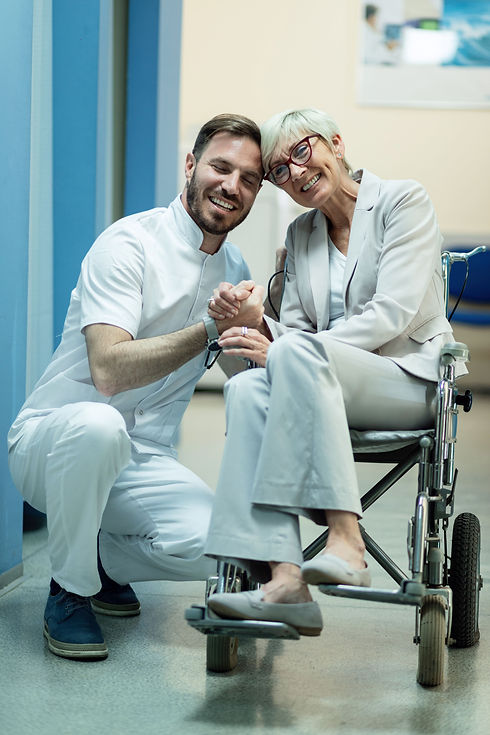 happy-mature-woman-wheelchair-holding-hands-with-her-doctor-hospital-hallway.jpg