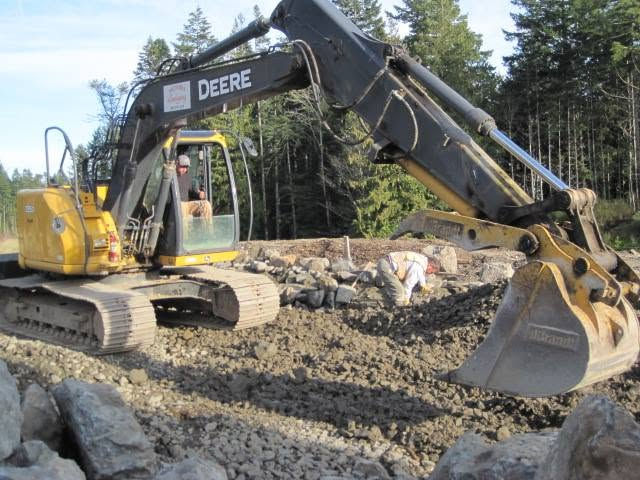 Victoria Landscaping Ltd crew member operating a large excavator to prepare a site