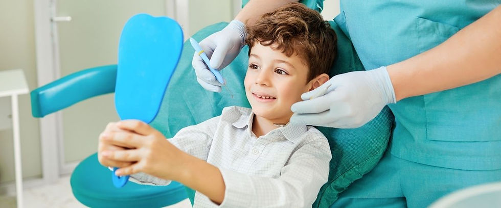Child in a dental chair smiling at a mirror in medicine hat