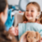 a young child happily high fiving her dental hygienist