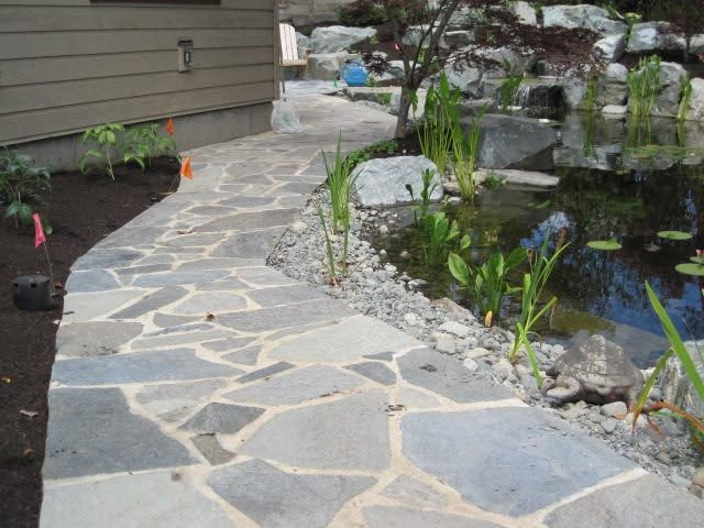 Slate pathway (installed by Victoria Landscaping Ltd) built around the pond feature on a saanich property