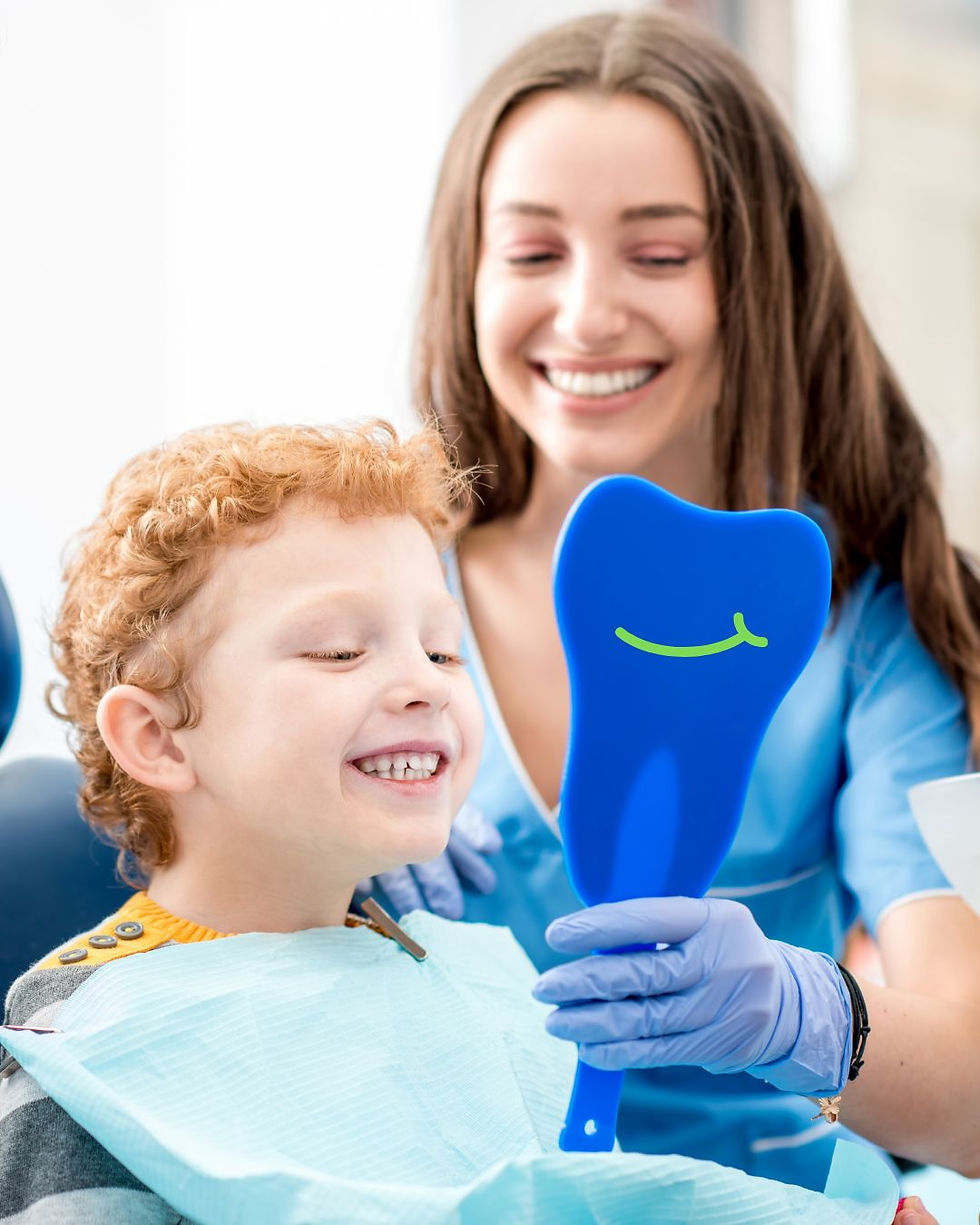 new patients welcome smiling child looking into tooth mirror.jpg