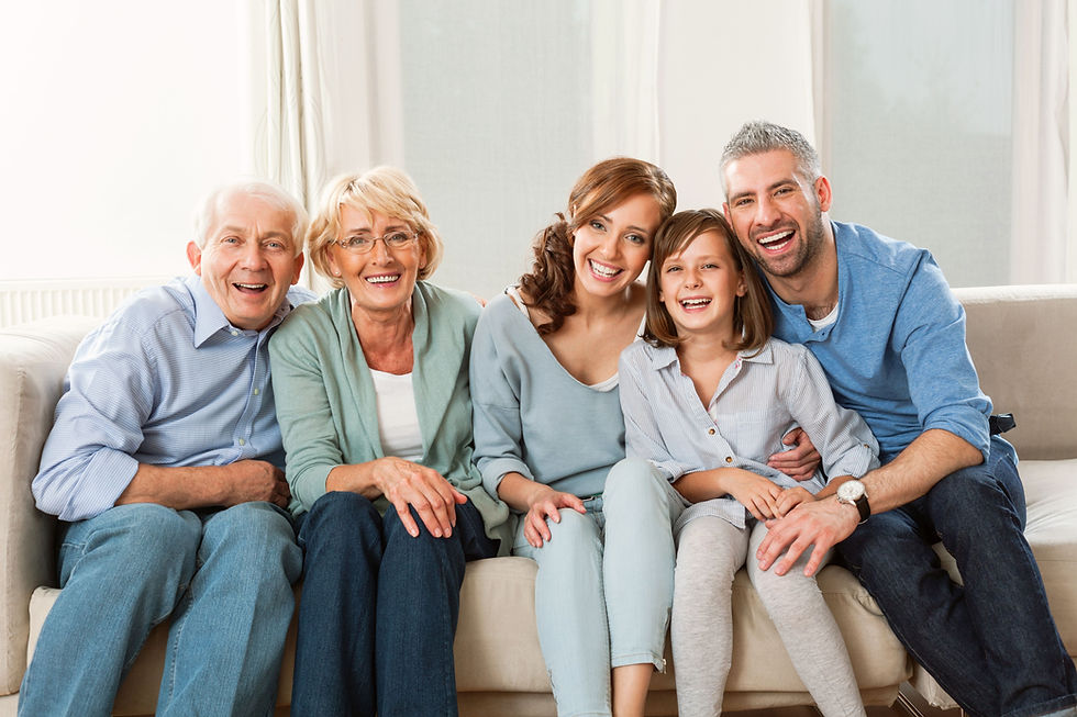 Family with grandparents sitting on a couch smiling