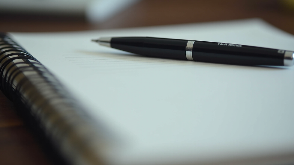 Close-up of a branded notebook and pen on a desk