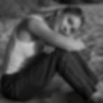 Black and white photo of founder Paige Benninghoff in a reflective, grounded posture representing intentional healing
