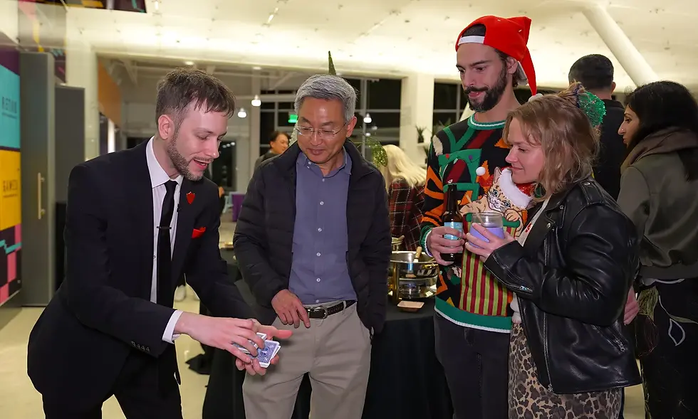 Silicon Valley magician Spencer Grey performing close up card magic for guests at a company party