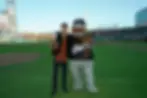 Magician Spencer Grey and Giants mascot Lou Seal hold up the signed baseball that vanished and reappeared at home plate