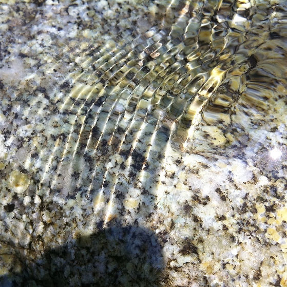 Wellen auf dem Wasser über einem Stein im Fluss als Cover für die Klangmeditation Klang Affirmationen