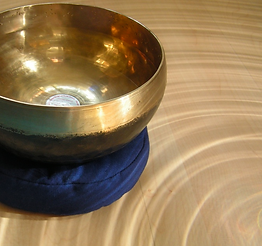 Messingfarbene Klangschale inmitten Kreisen aus Licht als Einladung für den Workshop zur Klangschalen Meditation Die Energie und der Fluss des Geldes / Geldenergie