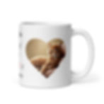 A cute, orange tabby cat reclining on a fancy bed, with a sassy expression on it's face, inside a heart shaped image frame.